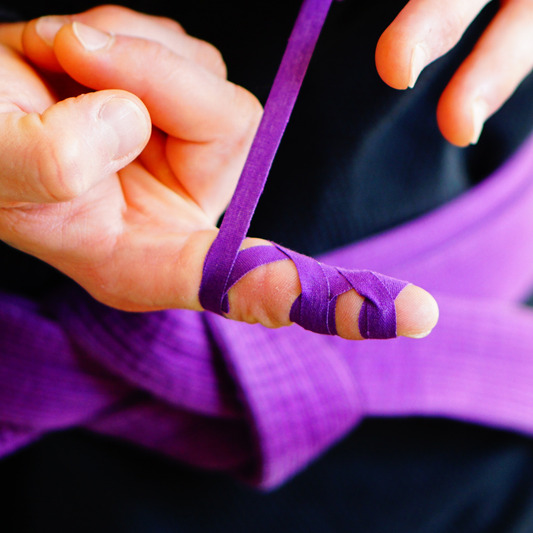 Finger wrapped with Sticky Grips purple 8mm BJJ finger tape low stretch 10m during grappling training