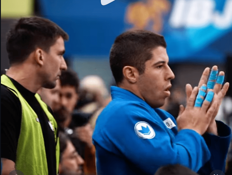 Jiu Jitsu athlete Tainan Dalpra with taped fingers preparing for competition – best BJJ finger tape for grip strength