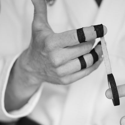 Applying Sticky Grips black 8mm BJJ finger tape low stretch 13.7m during grappling training