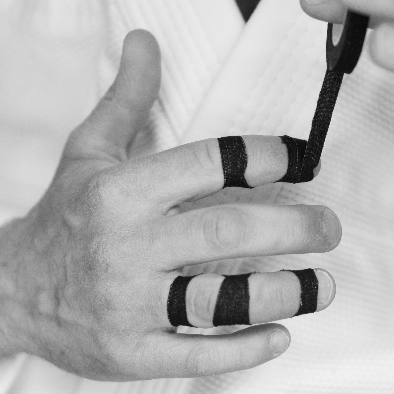 Finger wrapped with Sticky Grips black 8mm BJJ finger tape low stretch 13.7m during grappling training