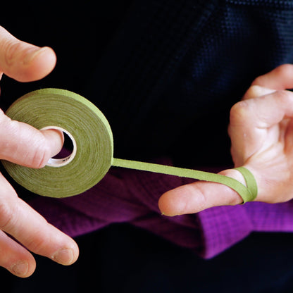 Sticky Grips low stretch BJJ finger tape khaki being wrapped around finger during training
